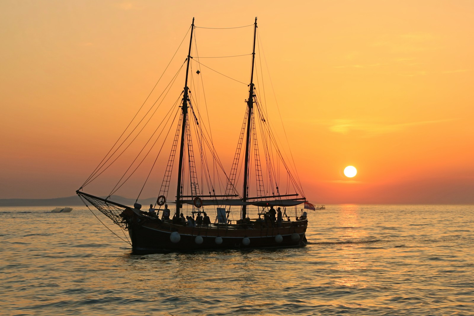 black and white boat in body of water during sunset